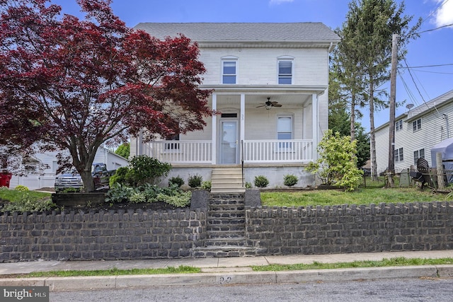 view of front of house featuring a ceiling fan, a porch, stairs, brick siding, and fence