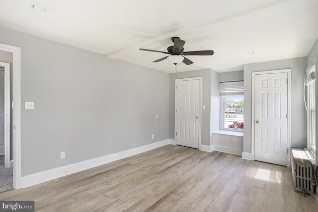 unfurnished bedroom with light wood-style floors, baseboards, ceiling fan, and radiator