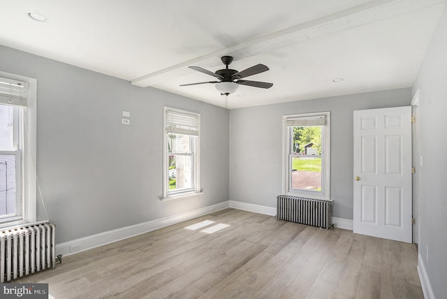 spare room with radiator heating unit, wood finished floors, baseboards, ceiling fan, and beamed ceiling