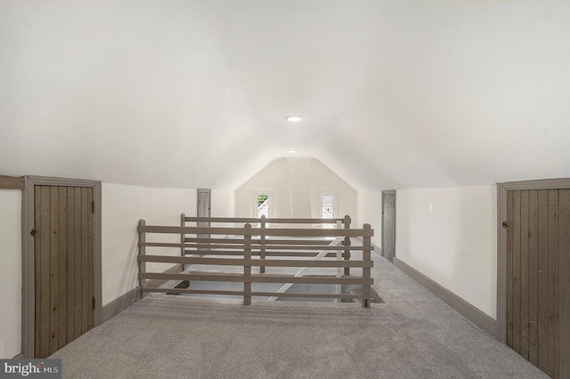 bonus room with carpet flooring, lofted ceiling, and baseboards