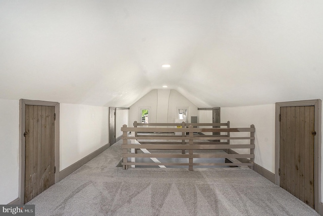 additional living space featuring carpet floors, lofted ceiling, and baseboards