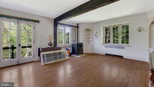 203 E Ferry Rd, Yardley, PA 19067 - interior space featuring hardwood / wood-style flooring, beam ceiling, a wood stove, built in shelves, and arched walkways