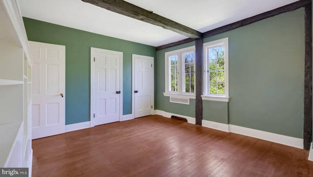 203 E Ferry Rd, Yardley, PA 19067 - unfurnished bedroom featuring beamed ceiling, wood finished floors, baseboards, and multiple closets