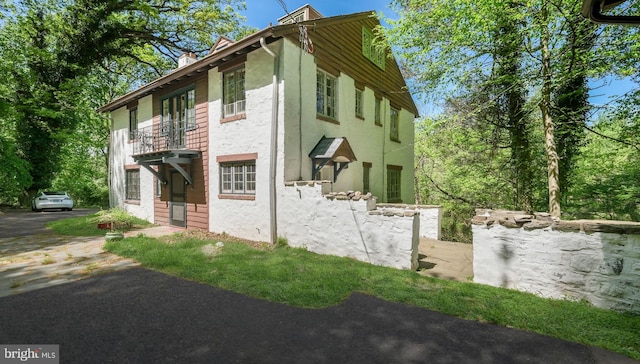 203 E Ferry Rd, Yardley, PA 19067 - view of property exterior featuring a balcony, a chimney, and stucco siding