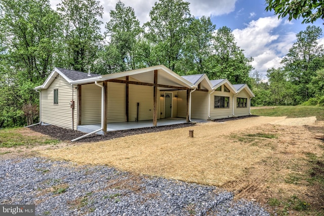 42 Heidi Rd, Delta, PA 17314 - view of front of home featuring gravel driveway, an attached carport, a patio area, and view of wooded area