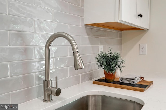 42 Heidi Rd, Delta, PA 17314 - kitchen view of a sink, tasteful backsplash, white cabinetry, and light stone countertops