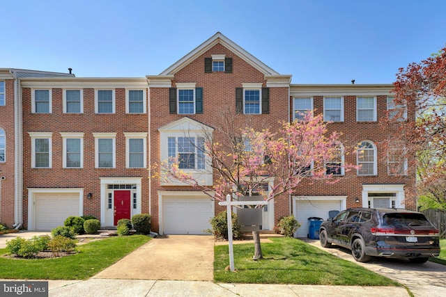 view of property with a front lawn, brick siding, driveway, and a garage