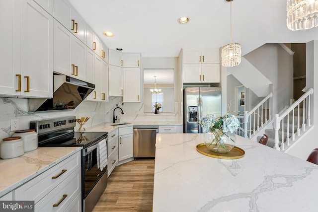 kitchen with a sink, stainless steel appliances, recessed lighting, a chandelier, and backsplash