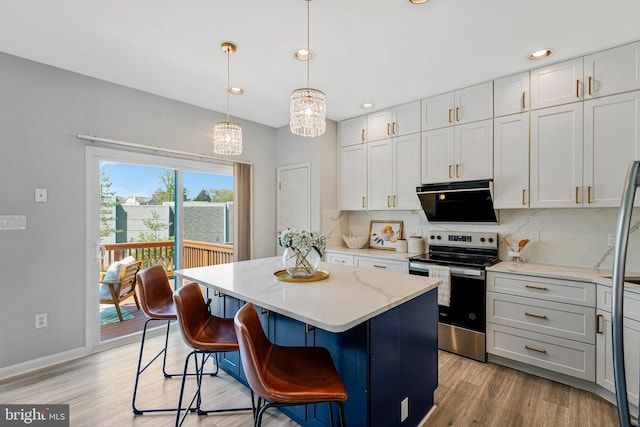 kitchen with an inviting chandelier, a center island, light wood-style flooring, stainless steel range with electric cooktop, and backsplash