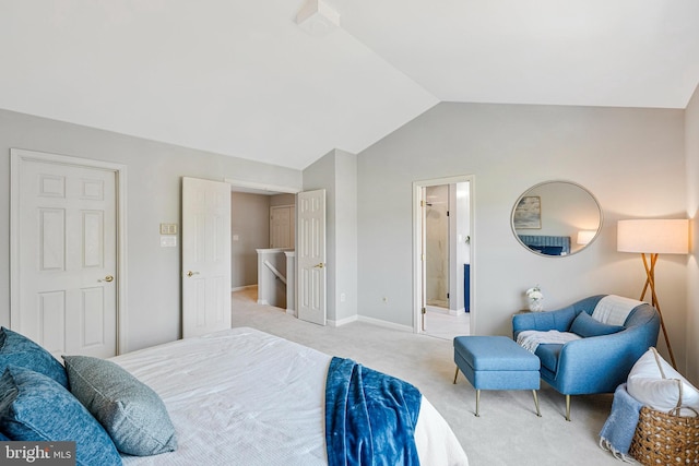 bedroom featuring lofted ceiling, light carpet, connected bathroom, and baseboards