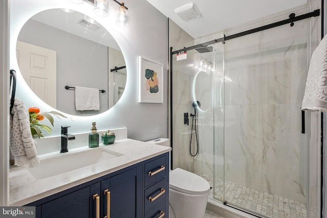 bathroom featuring toilet, visible vents, a marble finish shower, and vanity