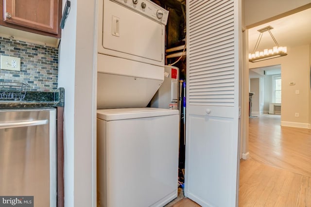 laundry area with light wood finished floors, stacked washing maching and dryer, and laundry area