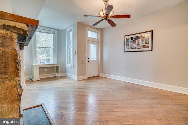 foyer entrance featuring plenty of natural light, wood finished floors, baseboards, and ceiling fan