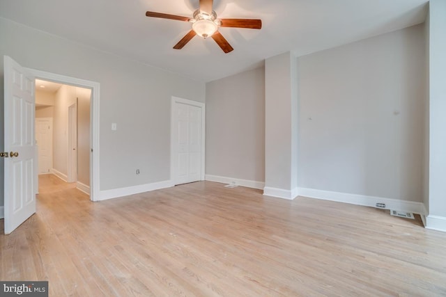 unfurnished room with baseboards, light wood finished floors, ceiling fan, and visible vents