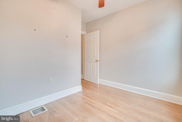 spare room with light wood-style floors, visible vents, baseboards, and ceiling fan