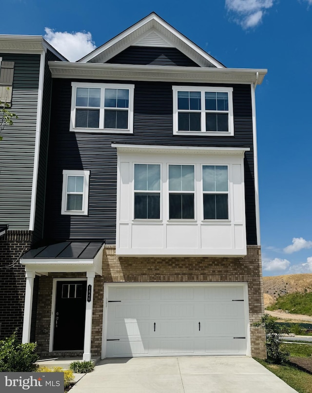 view of front of house featuring an attached garage, brick siding, and driveway