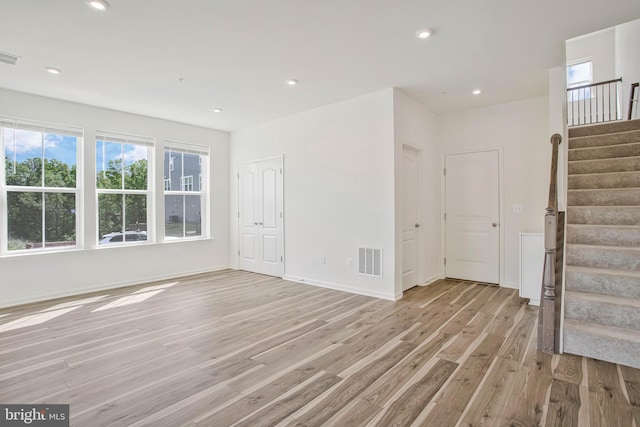 1646 Aster Ln, Hanover, MD 21076 - unfurnished living room featuring light wood finished floors, stairway, healthy amount of natural light, recessed lighting, and baseboards