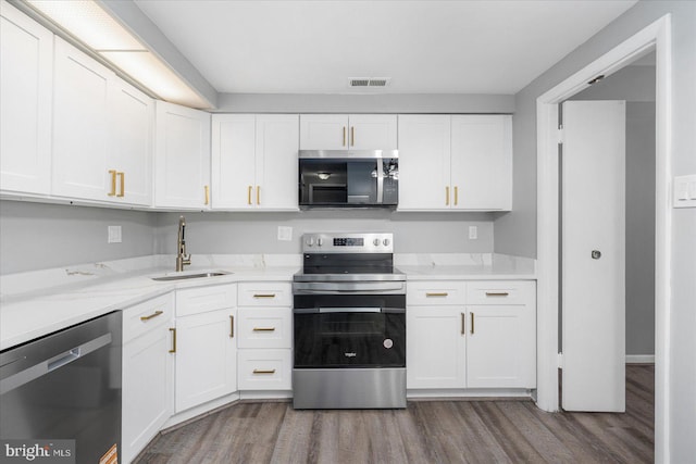 6317 Park Heights Ave Unit 616, Baltimore, MD 21215 - kitchen with a sink, stainless steel appliances, white cabinetry, dark wood finished floors, and visible vents