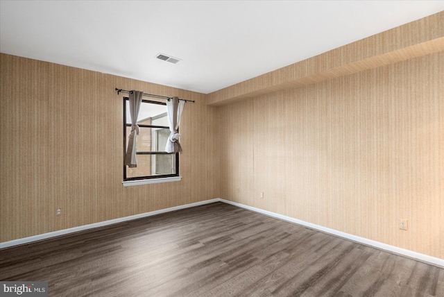 6317 Park Heights Ave Unit 616, Baltimore, MD 21215 - unfurnished room with wallpapered walls, visible vents, baseboards, and dark wood-type flooring