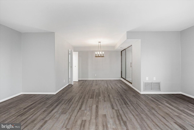 6317 Park Heights Ave Unit 616, Baltimore, MD 21215 - unfurnished room with dark wood-style flooring, a notable chandelier, baseboards, and visible vents