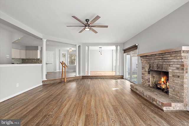 10288 Broken Sound Blvd, Ocean City, MD 21842 - unfurnished living room with ornate columns, healthy amount of natural light, a fireplace, and wood finished floors