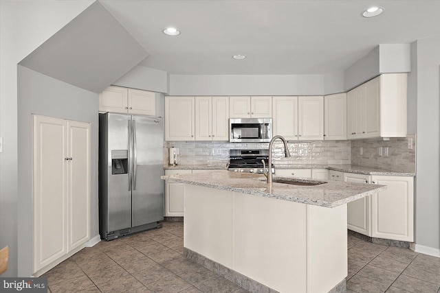 10288 Broken Sound Blvd, Ocean City, MD 21842 - kitchen with stainless steel appliances, a sink, tasteful backsplash, light stone counters, and a kitchen island with sink