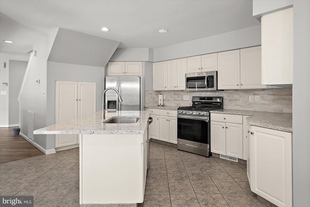 10288 Broken Sound Blvd, Ocean City, MD 21842 - kitchen with appliances with stainless steel finishes, a sink, backsplash, a center island with sink, and white cabinetry