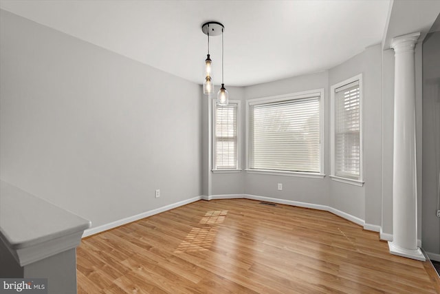 10288 Broken Sound Blvd, Ocean City, MD 21842 - unfurnished dining area with decorative columns, baseboards, and light wood-style floors