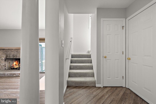 10288 Broken Sound Blvd, Ocean City, MD 21842 - staircase featuring a brick fireplace, wood finished floors, and baseboards