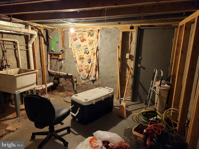 unfinished below grade area featuring electric panel and a sink
