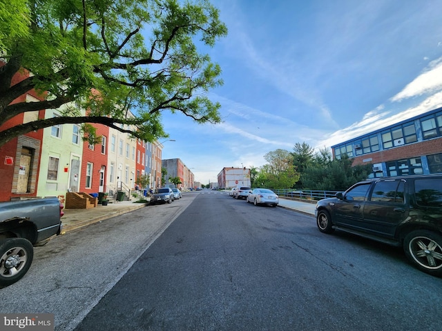 view of road featuring street lights, curbs, and sidewalks
