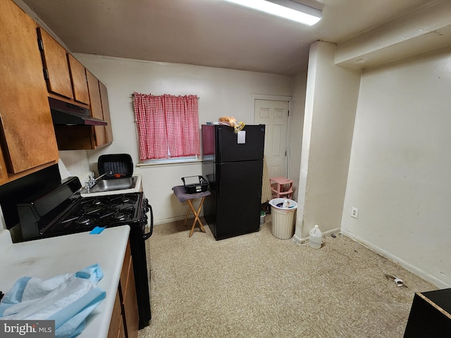 kitchen featuring under cabinet range hood, baseboards, black appliances, and brown cabinets