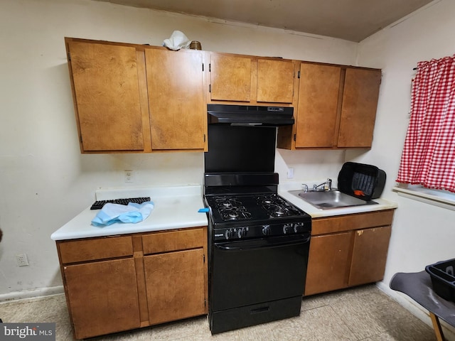 kitchen featuring under cabinet range hood, black range with gas cooktop, a sink, and light countertops