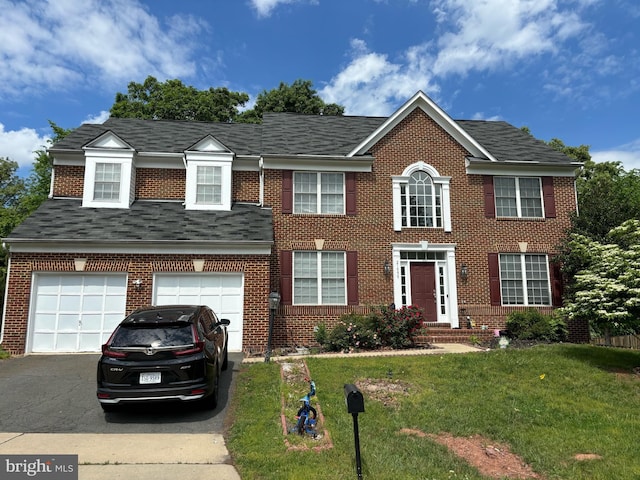 view of front facade featuring asphalt driveway, brick siding, a front lawn, and roof with shingles