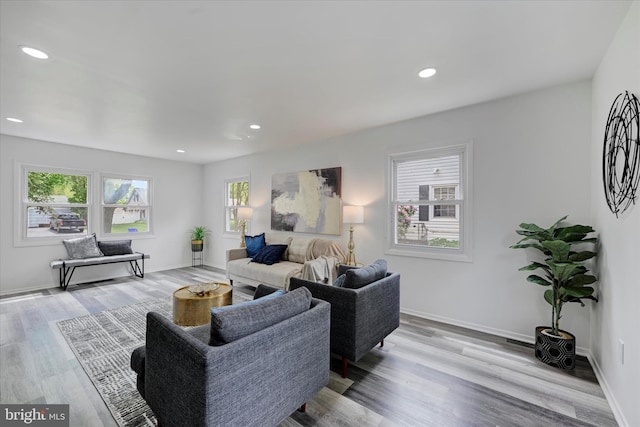 living room featuring plenty of natural light, light wood finished floors, recessed lighting, and baseboards