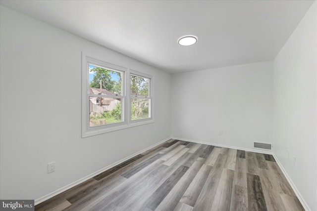 unfurnished room with wood finished floors and baseboards