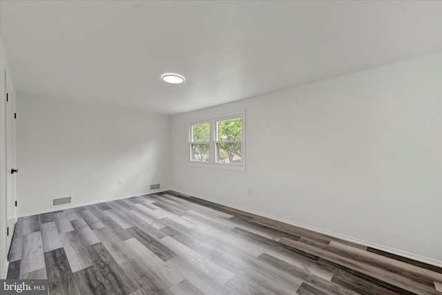 empty room featuring wood finished floors and baseboards