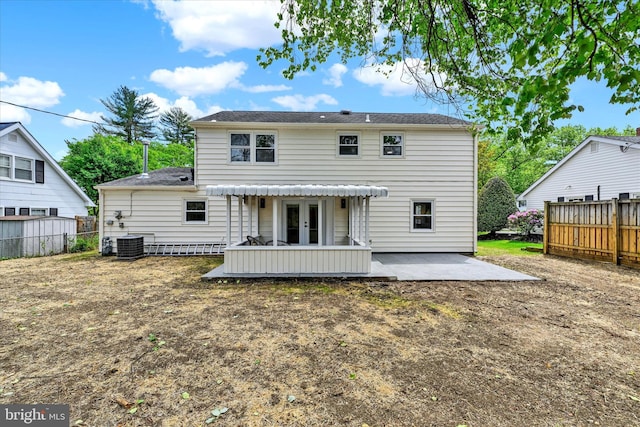 rear view of property featuring a patio area, french doors, fence, and central AC unit