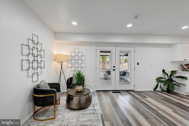 living area featuring wood finished floors, french doors, baseboards, and recessed lighting