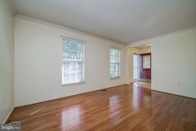 unfurnished room with ornamental molding, hardwood / wood-style floors, and baseboards