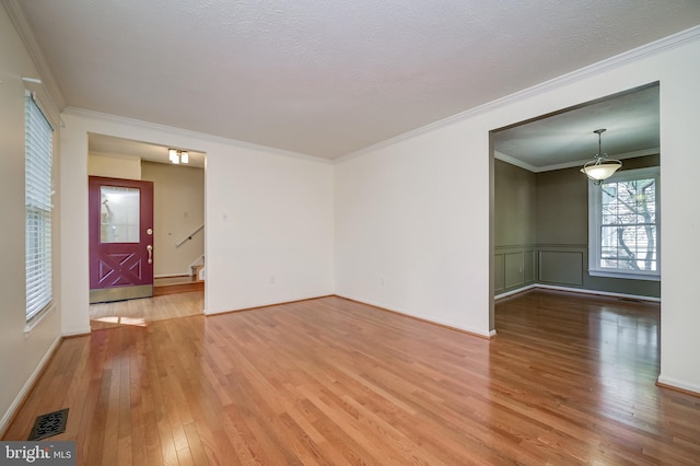 unfurnished living room featuring hardwood / wood-style floors, stairs, and ornamental molding