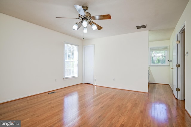 empty room featuring light wood finished floors, ceiling fan, and baseboards