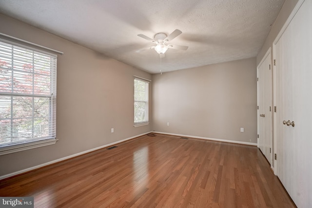 unfurnished bedroom featuring wood finished floors, baseboards, and ceiling fan