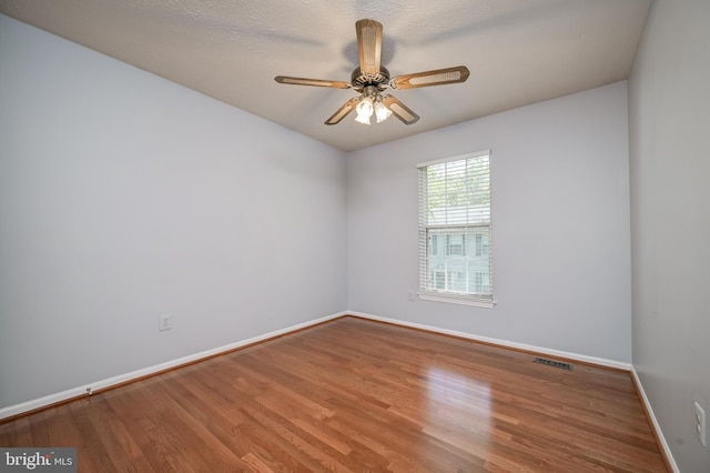 unfurnished room with baseboards, wood finished floors, and ceiling fan