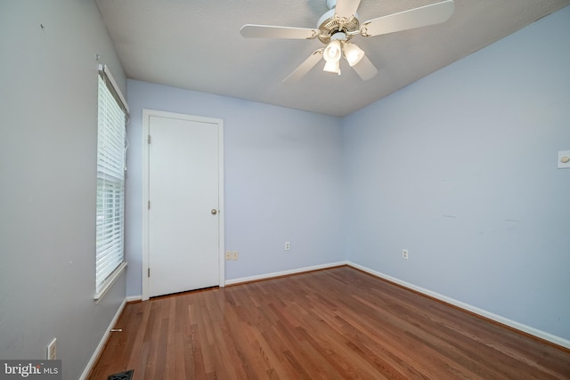 unfurnished room with baseboards, wood finished floors, and ceiling fan