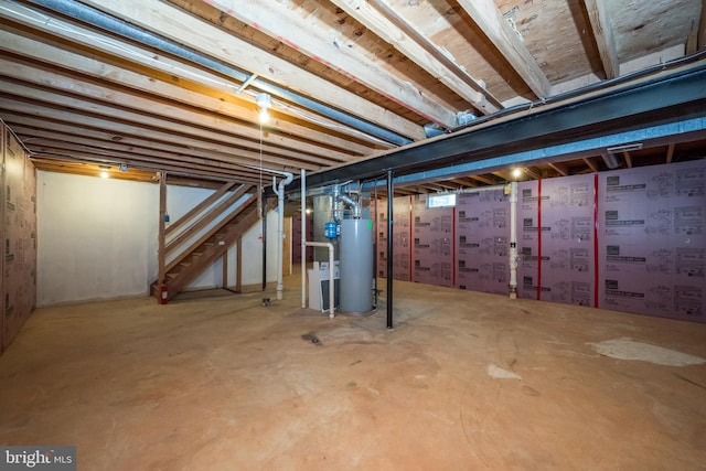 unfinished below grade area featuring gas water heater and stairway
