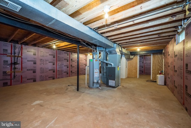 unfinished below grade area featuring water heater and heating unit