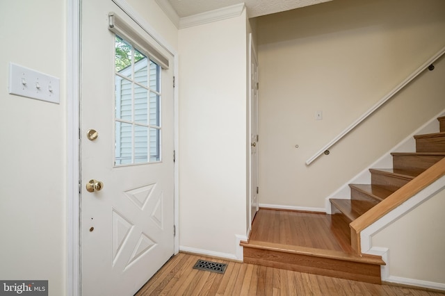 entryway with stairway, light wood-style flooring, and baseboards