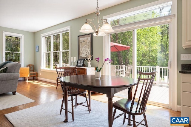 dining area featuring a chandelier, light wood finished floors, and baseboards