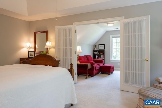 bedroom featuring lofted ceiling and light carpet